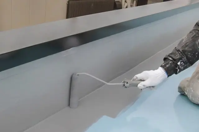 ローラーで防水材を塗布している様子